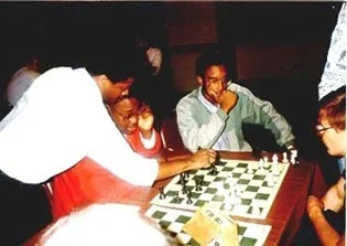 Maurice Ashley analyzing R.O. Mitchell’s game (with his seated opponent) at the 1989 U.S. Open in Chicago. R.O. Mitchell won the U.S. Junior Open in 1990. Kimani Stancil, Maryland’s Denker representative, looks on. Copyright © 1989, Daaim Shabazz.