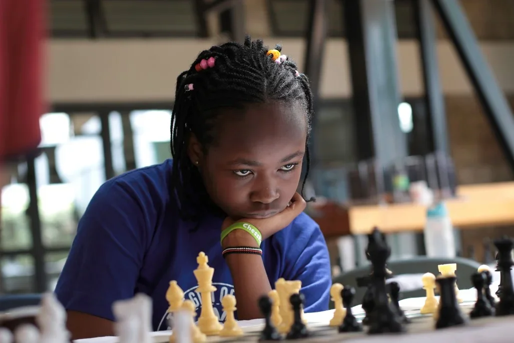 Bernice Wambui, staring intently at chess board
