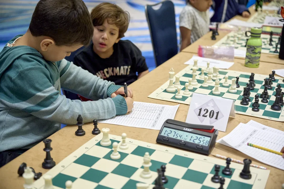 Mehmet Yilanli (1363) entered the tournament rated 400+ points ahead of his competition, and left with an unblemished 7/7 score. Julien Kulla (tied-fourth, sixth on tiebreaks) is seen studying the champ's moves.