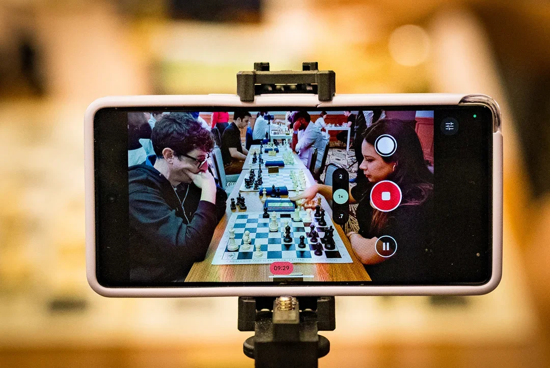 A picture of a phone filming Kostya Kavutskiy's blitz game against Thalia Cervantes
