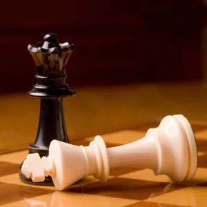 Black Queen with White King on its side, placed upon a chess board.
