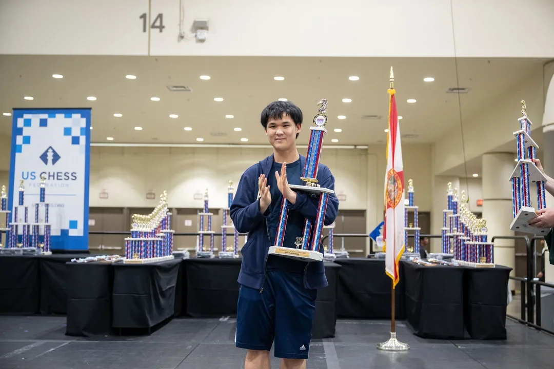 Awonder Liang holding the K-12 Blitz Team Championship trophy