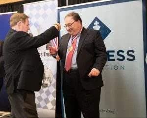 GM Alex Fishbein being presented his medal by Dewain Barber.