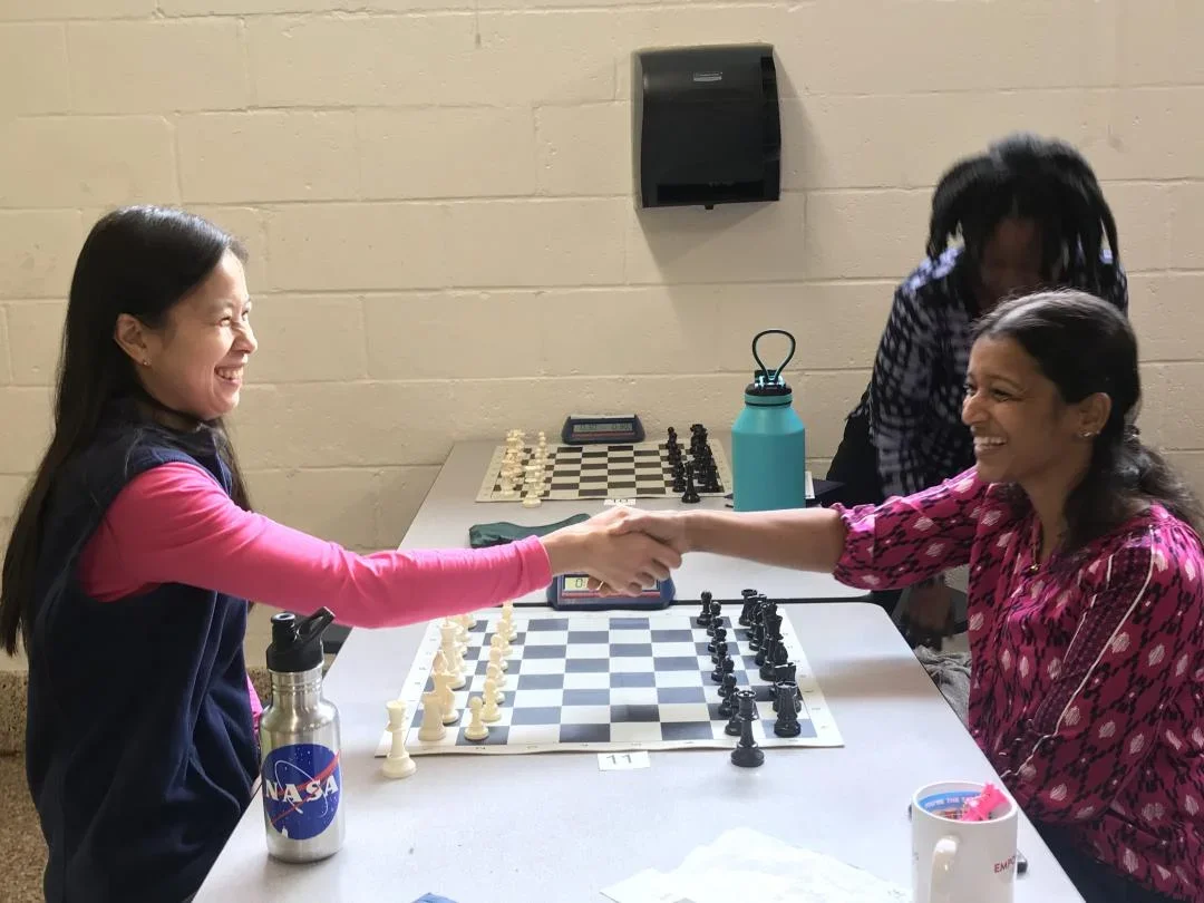 Chess Moms shake hands at an Indermaur Foundation event in October 2019