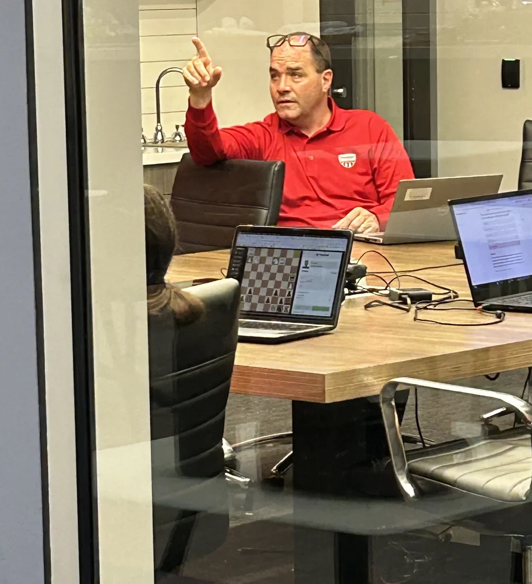 A student caught playing chess during a team meeting. Which US Chess would never condone.
