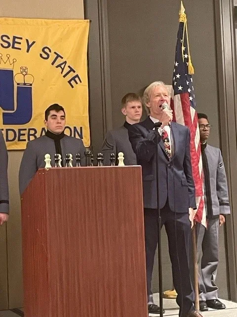 FM Nathan Resika sings the national anthem at the start of round 1, (courtesy Michael Somers)
