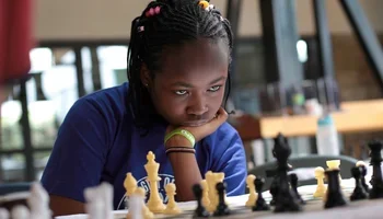 Bernice Wambui, staring intently at chess board