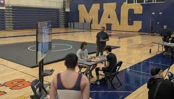 A chess game in front of a wrestling mat during the Chesswrestling Festival