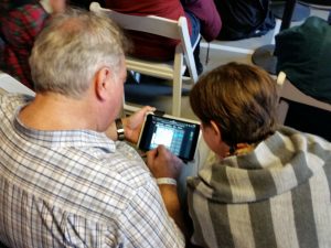 Two spectators following along on their mobile device. Photo by Daniel Lucas